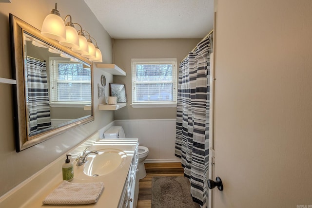 bathroom with hardwood / wood-style flooring, vanity, a textured ceiling, and toilet