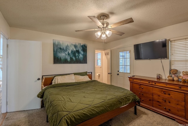 carpeted bedroom with ceiling fan and a textured ceiling