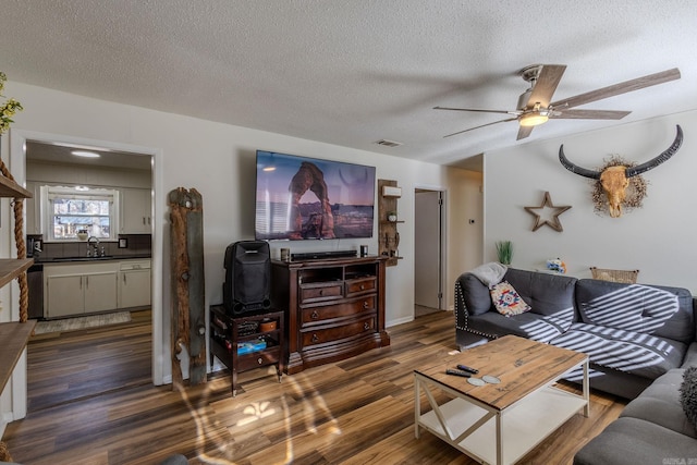 living room featuring a textured ceiling, dark hardwood / wood-style floors, ceiling fan, and sink