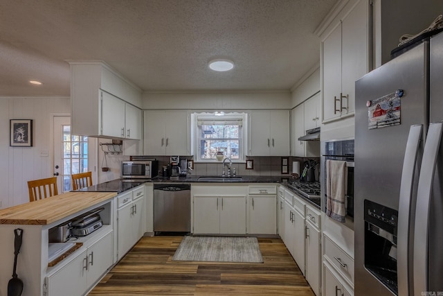 kitchen featuring appliances with stainless steel finishes, white cabinetry, and sink