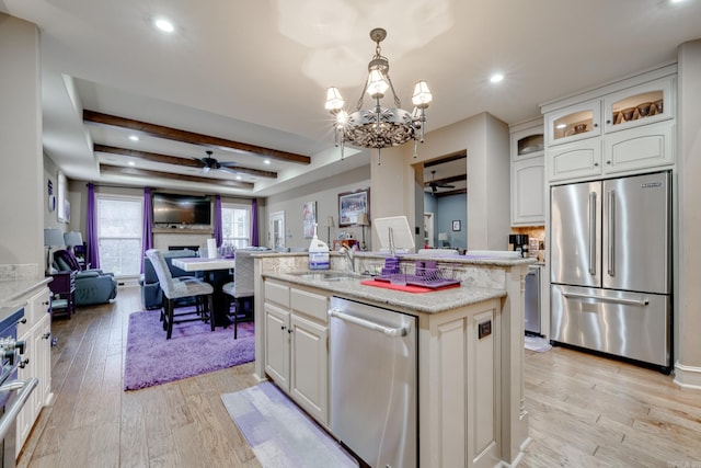 kitchen featuring pendant lighting, a center island with sink, white cabinetry, and appliances with stainless steel finishes