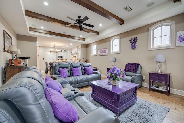 living room featuring light hardwood / wood-style floors and ceiling fan with notable chandelier