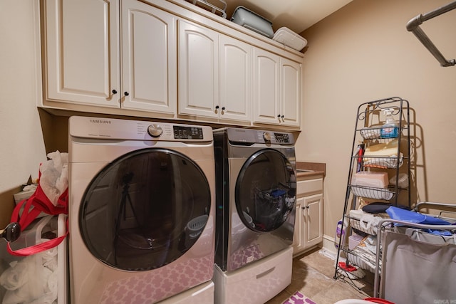 laundry area with cabinets, separate washer and dryer, and light tile patterned floors