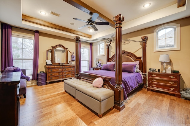 bedroom with a tray ceiling, ceiling fan, and light hardwood / wood-style floors