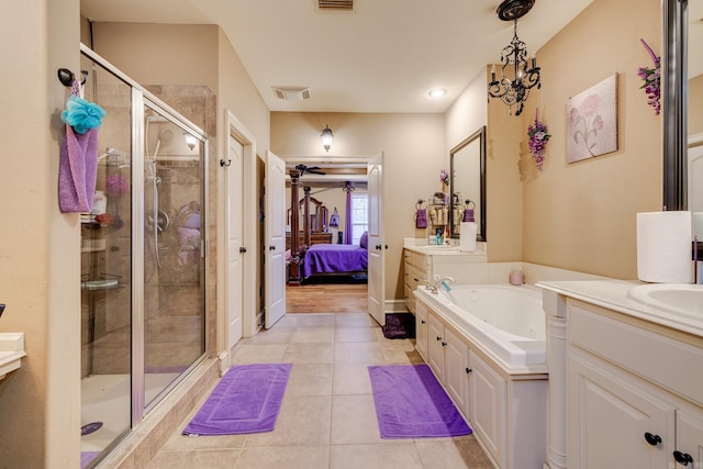 bathroom with tile patterned floors, vanity, a chandelier, and shower with separate bathtub