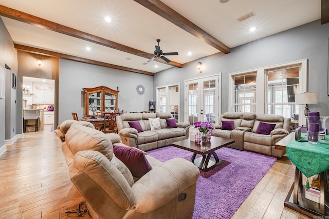 living room with beamed ceiling, ceiling fan, french doors, and light hardwood / wood-style flooring