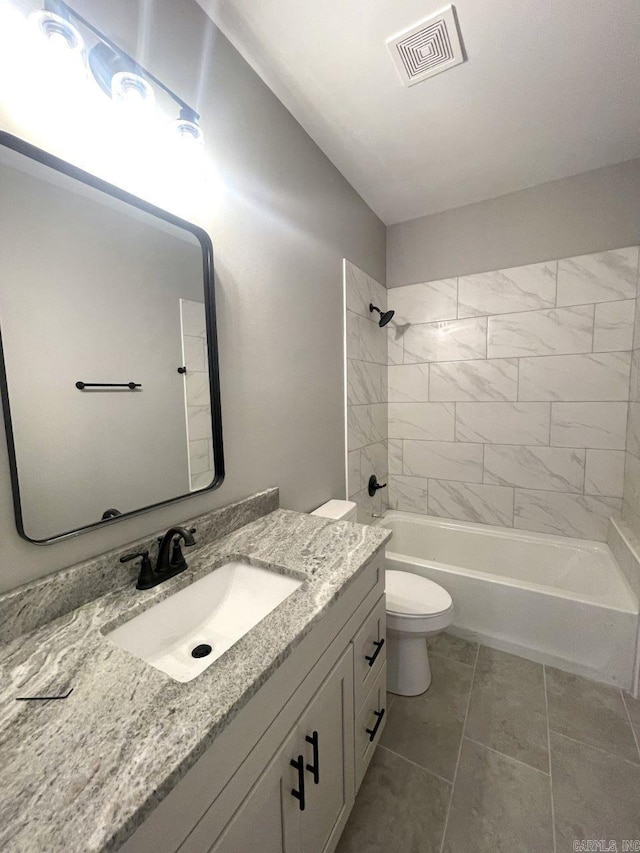 full bathroom with vanity, tiled shower / bath, tile patterned flooring, and toilet