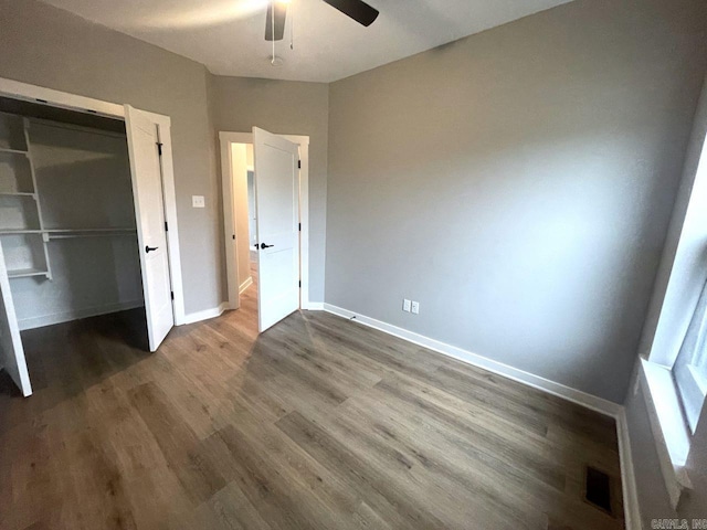 unfurnished bedroom with wood-type flooring, ceiling fan, and a closet