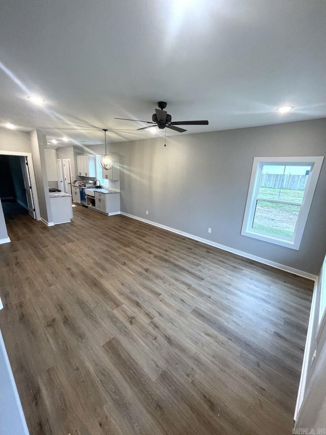 unfurnished living room with dark hardwood / wood-style floors and ceiling fan