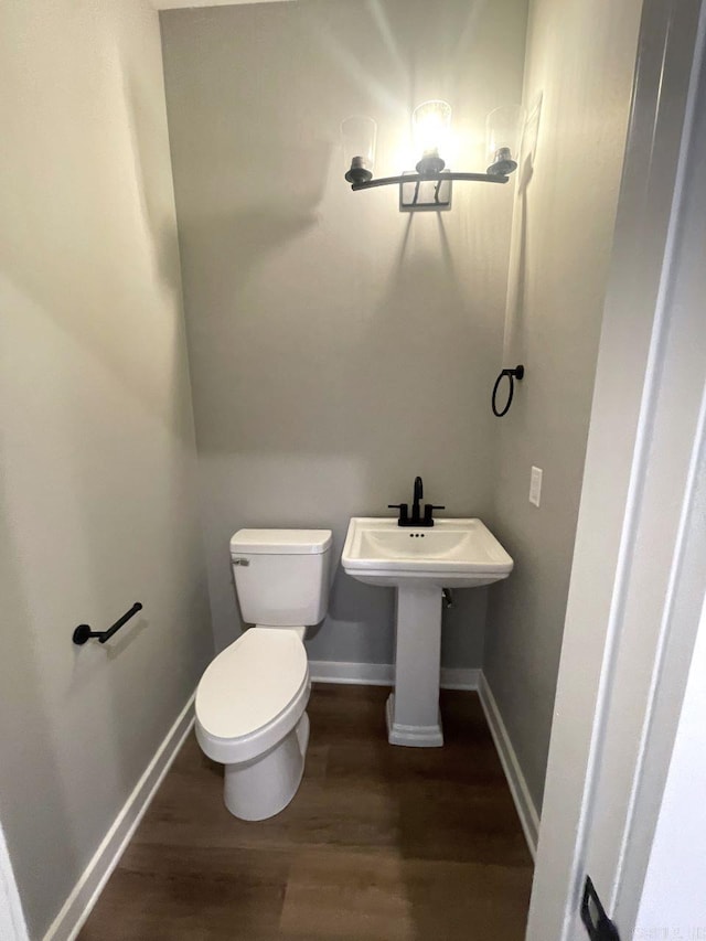 bathroom featuring wood-type flooring, sink, and toilet