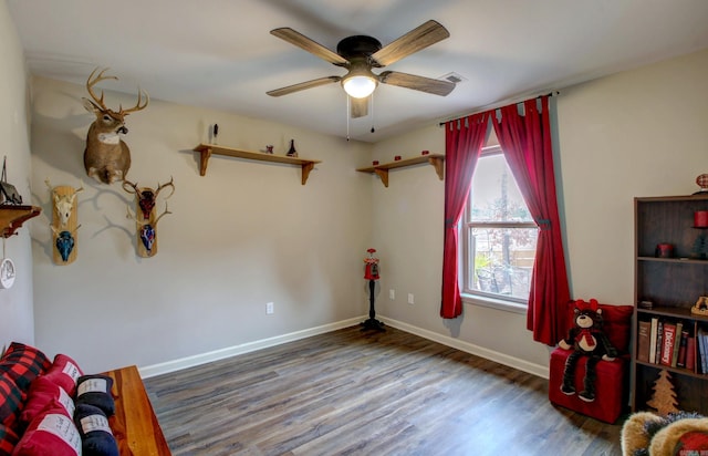 living area featuring ceiling fan and dark wood-type flooring