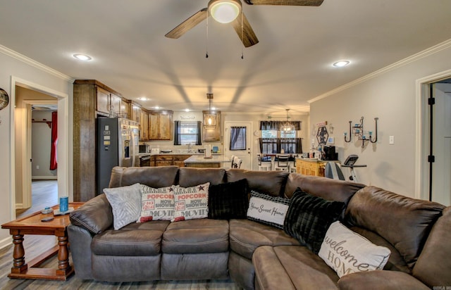 living room with ceiling fan, wood-type flooring, and ornamental molding