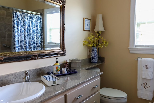 bathroom with a shower with curtain, vanity, and toilet