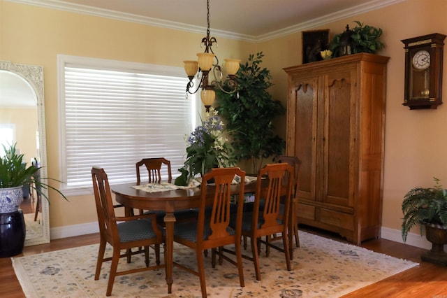 dining room featuring ornamental molding, a notable chandelier, and hardwood / wood-style flooring