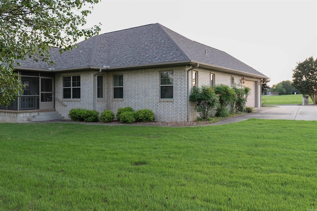 view of home's exterior with a lawn, a sunroom, and a garage