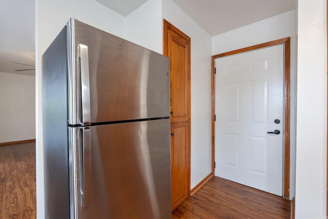 kitchen with dark hardwood / wood-style flooring and stainless steel refrigerator