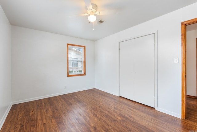 unfurnished bedroom with dark wood-type flooring, ceiling fan, and a closet