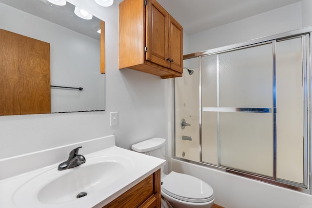 full bathroom featuring vanity, toilet, and combined bath / shower with glass door