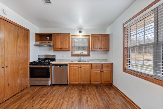 kitchen with appliances with stainless steel finishes, sink, and dark wood-type flooring