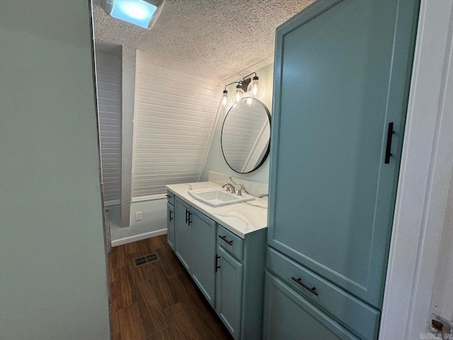 bathroom with vanity, wood-type flooring, and a textured ceiling