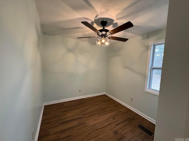 empty room featuring a textured ceiling, ceiling fan, and dark hardwood / wood-style floors