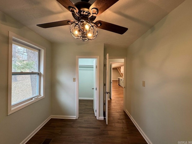 hallway with a textured ceiling and dark hardwood / wood-style floors