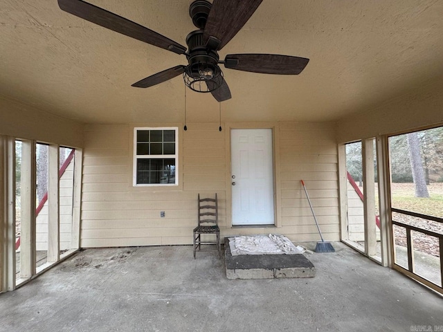 unfurnished sunroom featuring a wealth of natural light and ceiling fan