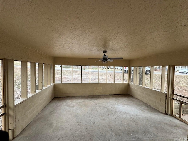 unfurnished sunroom with ceiling fan