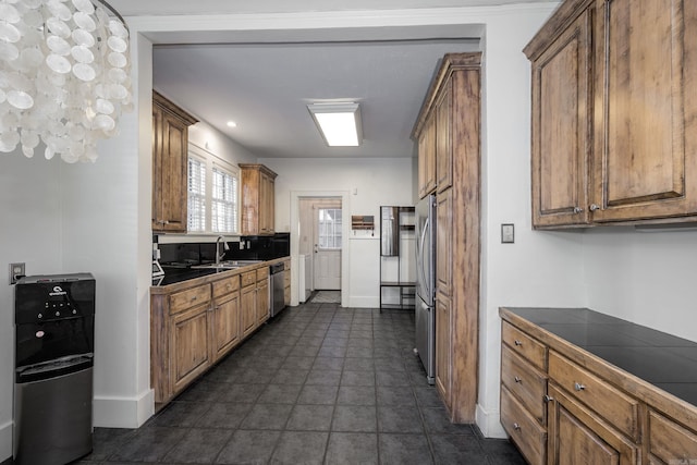 kitchen featuring tile counters, sink, and stainless steel appliances