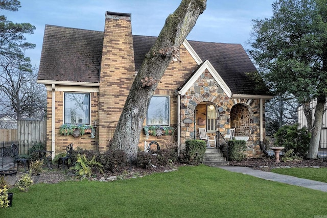 tudor-style house with a front lawn and covered porch