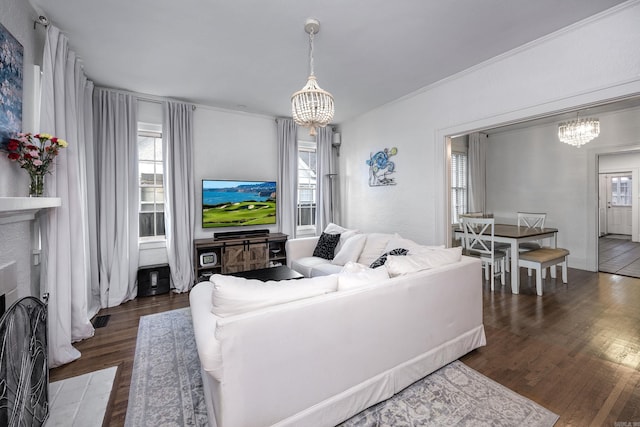 living room featuring a healthy amount of sunlight, dark hardwood / wood-style floors, and a notable chandelier