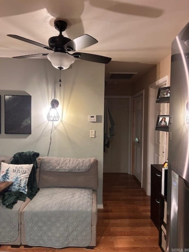 bedroom featuring stainless steel fridge, ceiling fan, and dark wood-type flooring