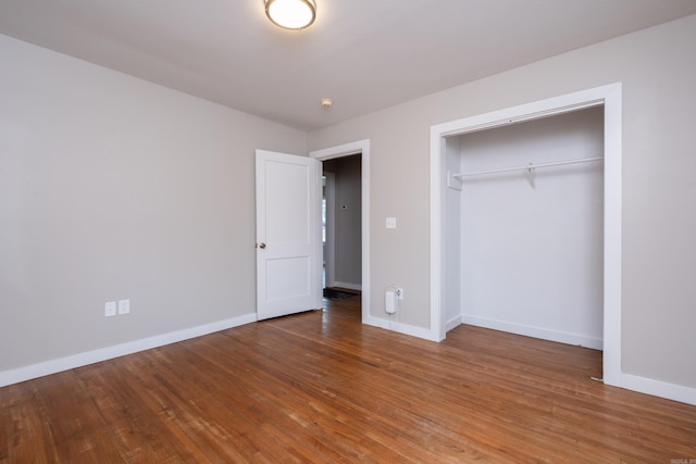 unfurnished bedroom with hardwood / wood-style floors and a closet