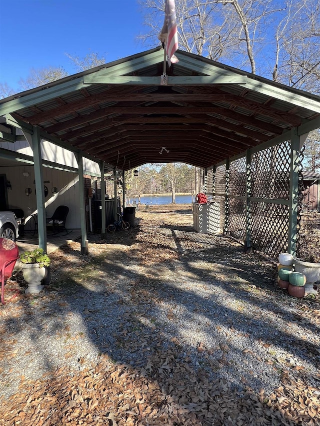 view of parking with a water view and a carport