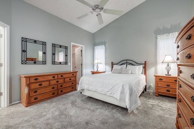 bedroom with vaulted ceiling, a closet, light colored carpet, ceiling fan, and a walk in closet