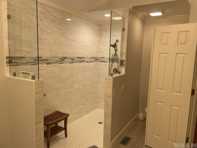 bathroom featuring tiled shower, crown molding, and toilet