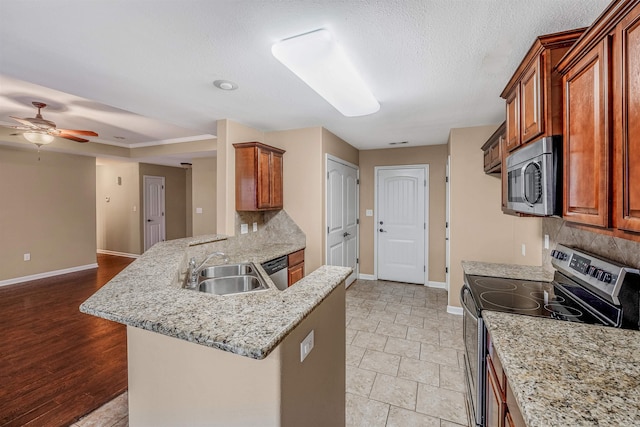 kitchen featuring kitchen peninsula, appliances with stainless steel finishes, backsplash, ceiling fan, and sink