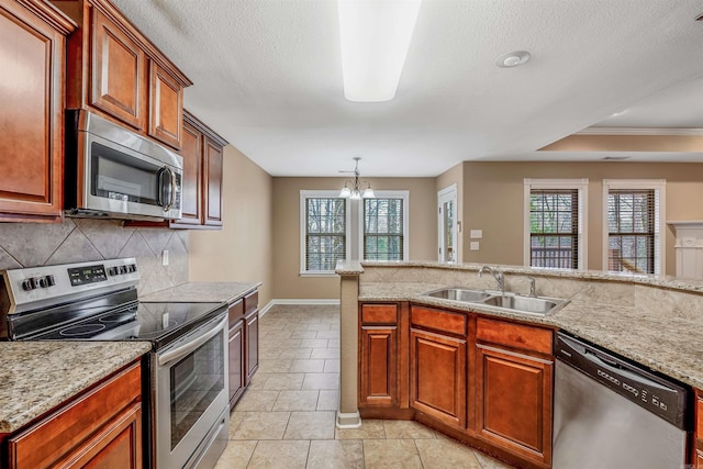 kitchen featuring light stone countertops, stainless steel appliances, crown molding, sink, and a chandelier