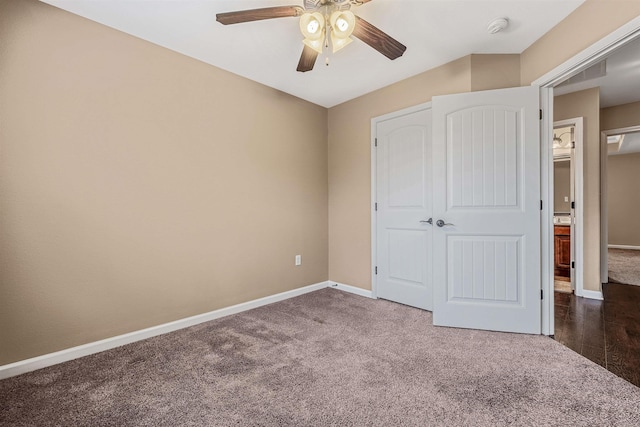 unfurnished bedroom with ceiling fan, dark carpet, and a closet