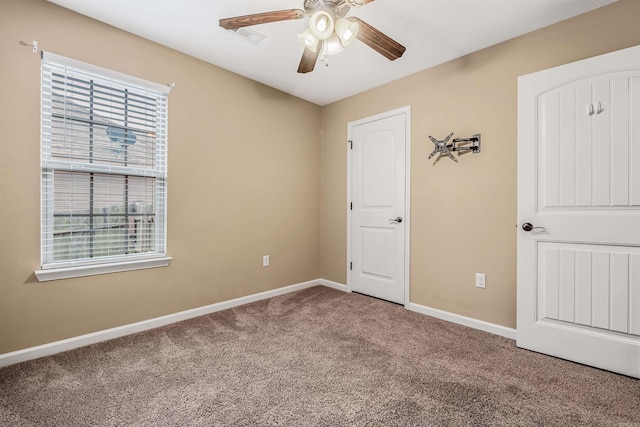 carpeted empty room featuring ceiling fan