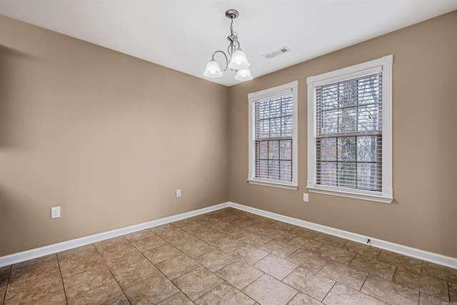 spare room featuring a notable chandelier