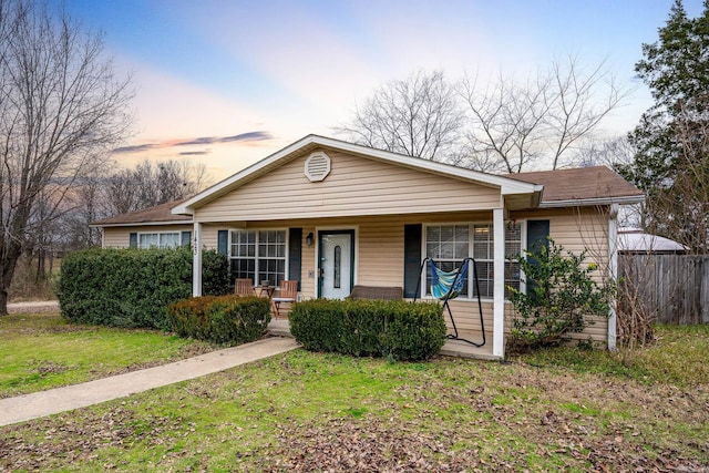 view of front of house featuring covered porch and a yard