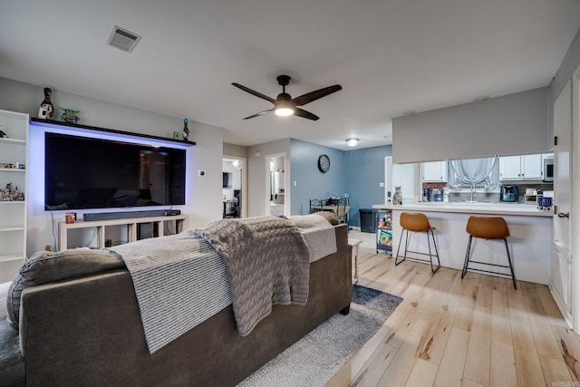 living room with light hardwood / wood-style flooring and ceiling fan