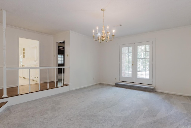 unfurnished room featuring carpet, french doors, crown molding, and a chandelier