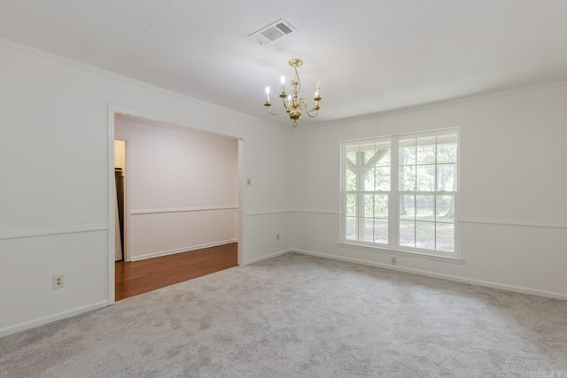 carpeted spare room with crown molding and a notable chandelier