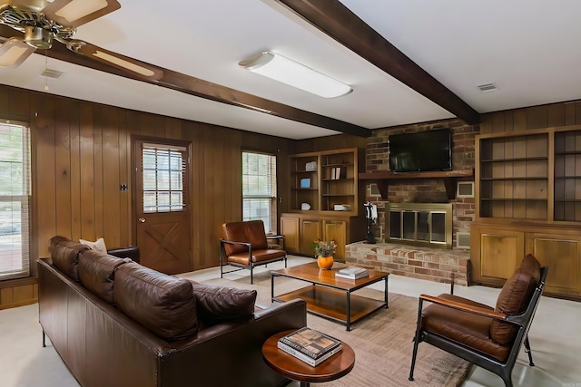 carpeted living room with wood walls, plenty of natural light, and beam ceiling