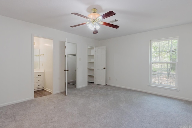 unfurnished bedroom featuring carpet flooring, ceiling fan, and connected bathroom