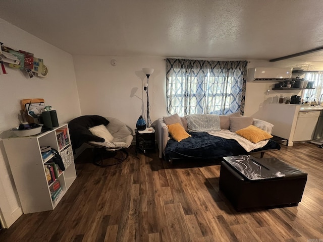 living room with a wall mounted air conditioner, a textured ceiling, and dark wood-type flooring