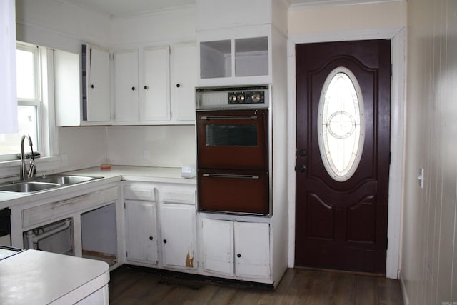 kitchen with white cabinetry, oven, and sink