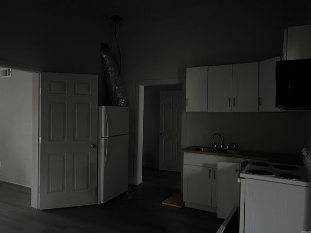 kitchen with white appliances, white cabinetry, and sink